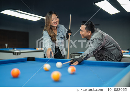 couple of pool players looking each other while playing billiard together couple of pool players looking each other while playing billiard together 104882065