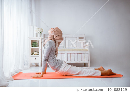 asian muslim woman bhujangsana cobra yoga pose wearing hijab on pilates matress asian muslim woman bhujangsana cobra yoga pose wearing hijab on pilates matress 104882129