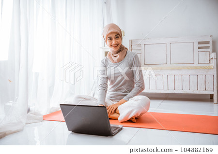 muslim hijab woman watching home work out tutorial from laptop 104882169