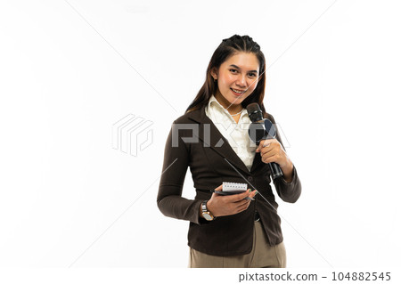a female journalist standing bring a microphone and notebook 104882545