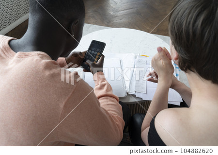 Couple of young people doing house paperwork 104882620
