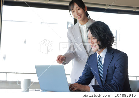 微笑著潛心創作素材的商人和檢查素材的女同事_1 微笑著潛心創作素材的商人和檢查素材的女同事_1 104882919