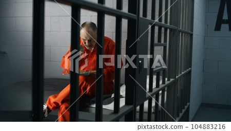 Elderly prisoner eats food sitting in prison cell in jail Elderly prisoner eats food sitting in prison cell in jail 104883216