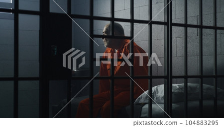 Elderly criminal sits and talks with cellmate 104883295