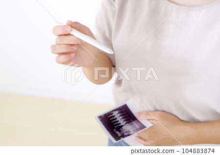 Young woman with ultrasound photo of pregnancy test Young woman with ultrasound photo of pregnancy test 104883874