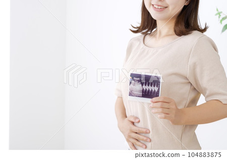 Young woman with ultrasound photo of pregnancy test Young woman with ultrasound photo of pregnancy test 104883875