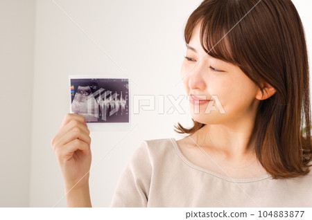 有妊娠試驗超聲波照片的年輕婦女 有妊娠試驗超聲波照片的年輕婦女 104883877