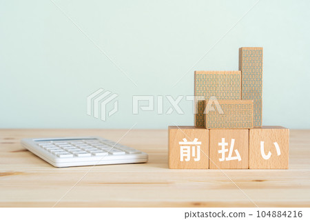 A block that says advance payment, a calculator, and a miniature building 104884216