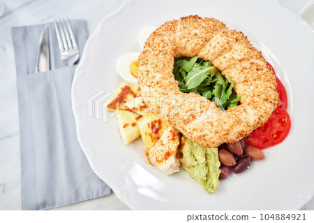 Turkish breakfast with simit, cheese, tomato, cucumber, olives. Breakfast with coffee in the restaurant. Morning nutritious meal Turkish breakfast with simit, cheese, tomato, cucumber, olives. Breakfast with coffee in the restaurant. Morning nutritious meal 104884921