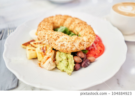 Turkish breakfast with simit, cheese, tomato, cucumber, olives. Breakfast with coffee in the restaurant. Morning nutritious meal Turkish breakfast with simit, cheese, tomato, cucumber, olives. Breakfast with coffee in the restaurant. Morning nutritious meal 104884923