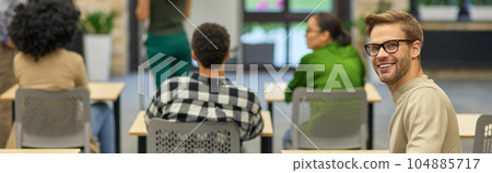 Cheerful caucasian man smiling at camera during business seminar or training 104885717
