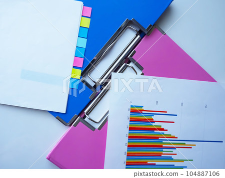 Binders and graphs on the table, documents with sticky notes Binders and graphs on the table, documents with sticky notes 104887106