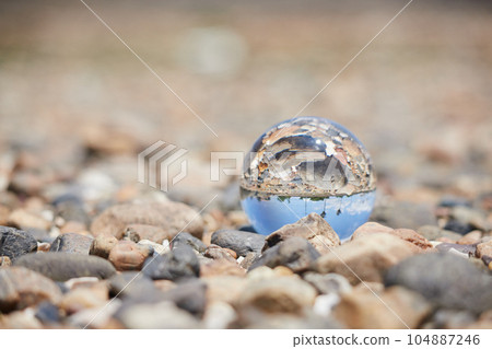 Scenery of transparent crystal glass ball on the beach of the sea Scenery of transparent crystal glass ball on the beach of the sea 104887246
