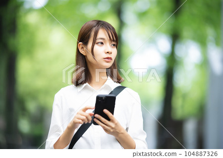 A woman to search on a smartphone A woman to search on a smartphone 104887326