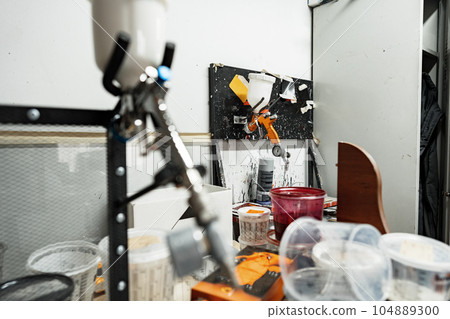 Airbrush paint gun in paint in car service station 104889300