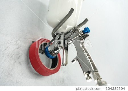 Airbrush paint gun in paint in car service station 104889304