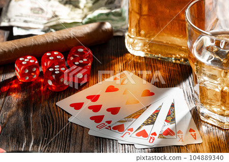Playing poker with whiskey and cigars on table 104889340