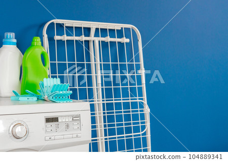 Blue clothes pins on white washing machine Blue clothes pins on white washing machine 104889341