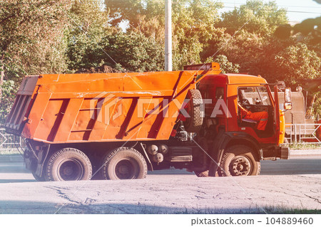 Road works. Workers repair the asphalt pavement of the road. 104889460