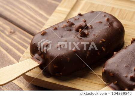 Chocolate cake pops ice creams on wooden board close up Chocolate cake pops ice creams on wooden board close up 104889843
