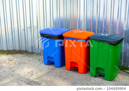 Color garbage bins in the city street on metal background Color garbage bins in the city street on metal background 104889904