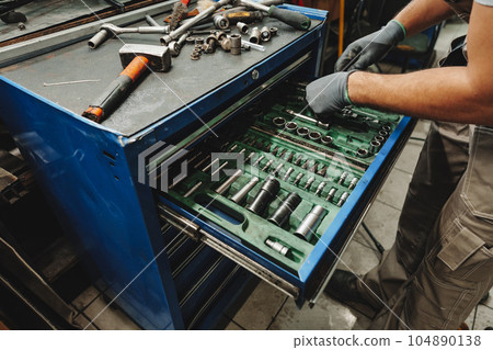 Male technician standing near tool table in car service 104890138