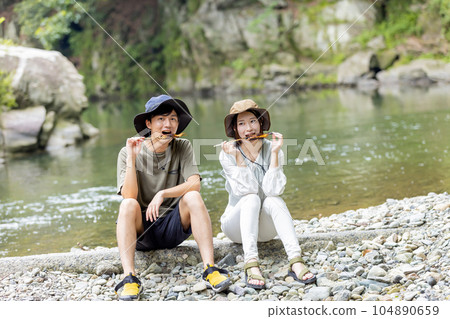 一對夫婦在河原吃香魚 104890659