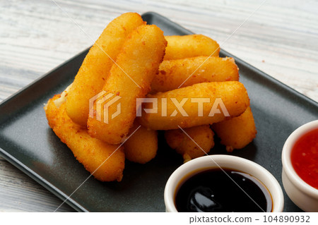 Fried snacks platter with sauce on gray wooden table 104890932