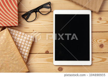 Top view of wooden table with white digital tablet with black screen on it Top view of wooden table with white digital tablet with black screen on it 104890935