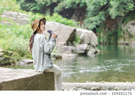 一位女士在河床上享受觀鳥的樂趣 104891278