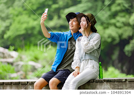 Young couple taking pictures at the campsite 104891304