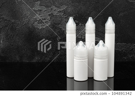Electronic cigarette vape liquids on black background Electronic cigarette vape liquids on black background 104891342