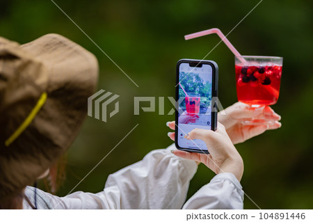 Young woman having a nice drink outdoors 104891446