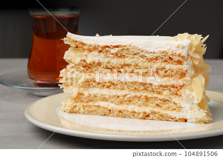 Piece of cake on plate with cup of tea on gray table Piece of cake on plate with cup of tea on gray table 104891506