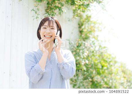 Portrait of a woman in her thirties making a phone call Portrait of a woman in her thirties making a phone call 104891522