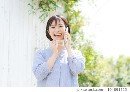 Portrait of a woman in her thirties making a phone call Portrait of a woman in her thirties making a phone call 104891523