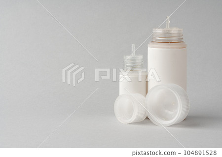 Refill liquid for electronic cigarettes on gray background 104891528