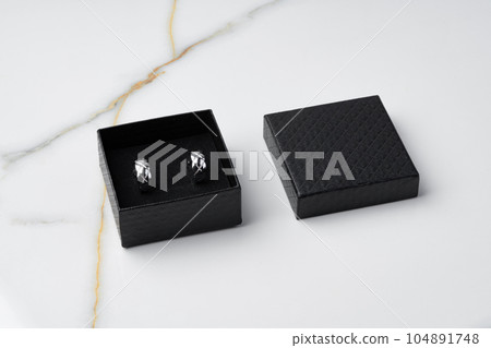 Golden earrings and jewelry box on table close up 104891748