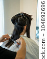 Woman getting a haircut at a beauty salon 104892696