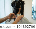Woman getting a haircut at a beauty salon 104892700