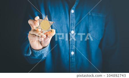 Man holds sheriff badge wear blue jeans shirt. Man holds sheriff badge wear blue jeans shirt. 104892743