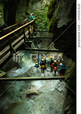 Group of people canyoning in the Seisenkergklamm gorge at Weissbach bei Lofer in Austria Group of people canyoning in the Seisenkergklamm gorge at Weissbach bei Lofer in Austria 104892826