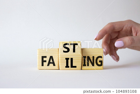 Fasting vs Failing symbol. Businessman hand points at wooden cubes with words Failing and Fasting. Beautiful white background. Fasting vs Failing and business concept. Copy space 104893108