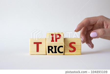 Tips and Tricks symbol. Businessman Hand points at wooden cubes with words Tricks and Tips. Beautiful white background. Business and Tips and Tricks concept. Copy space Tips and Tricks symbol. Businessman Hand points at wooden cubes with words Tricks and Tips. Beautiful white background. Business and Tips and Tricks concept. Copy space 104893109