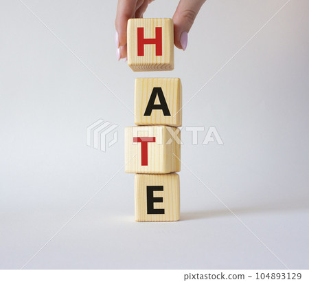 Hate symbol. Concept word Hate on wooden cubes. Businessman hand. Beautiful white background. Business and Hate concept. Copy space. 104893129