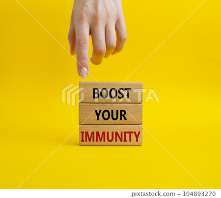 Boost your immunity symbol. Concept word Boost your immunity on wooden blocks. Doctor hand. Beautiful yellow background. Helthcare and Boost your immunity concept. Copy space 104893270