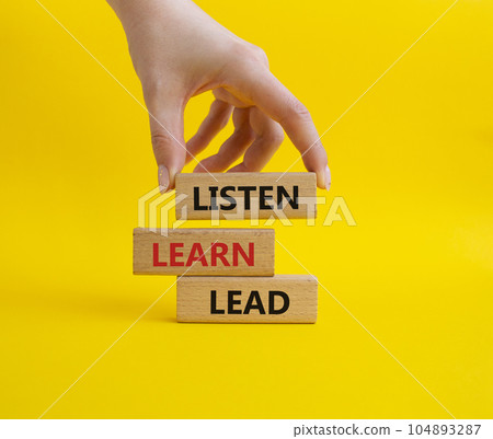 Listen Learn Lead symbol. Concept words Listen Learn Lead on wooden blocks. Beautiful yellow background. Businessman hand. Business and Listen Learn Lead concept. Copy space. 104893287