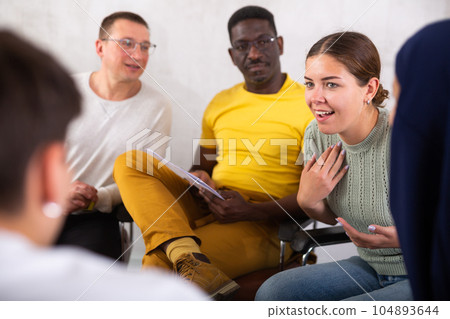 Cheerful young girl talking to colleagues in office lounge during break 104893644