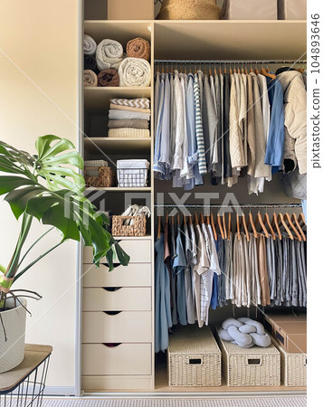 Modern wardrobe with stylish women's clothing. Concept of decluttering, organizing and tidiness 104893646