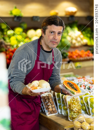 Adult man selling papaya and roots in shop 104893748